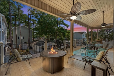 Wooden deck with outdoor dining space, a fire pit, and a ceiling fan