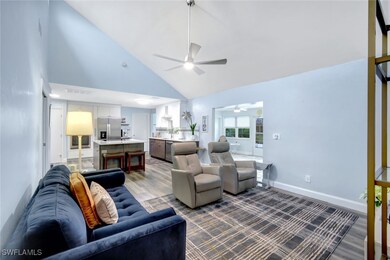 Living room featuring high vaulted ceiling, sink,
