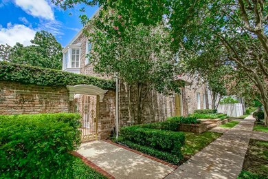 Pretty tree lined street w/ brick wall and wrought