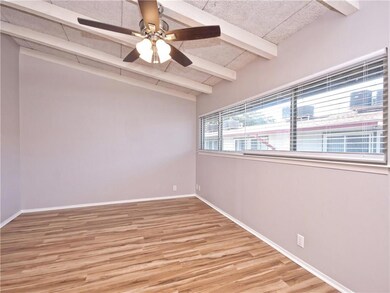 Empty room with wood finished floors, vaulted cei