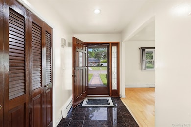 Entryway featuring granite tiled floors, healthy amount of natural light, and a baseboard radiator