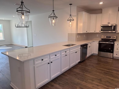 Kitchen featuring white cabinetry, light stone cou