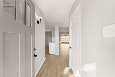 BRIGHT AND OPEN ENTRY HALL WITH LIGHT LUXURY VINYL PLANK FLOORING.