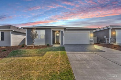 Ranch-style house featuring concrete driveway, an attached garage, and a front yard