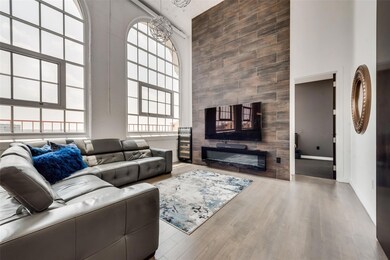 Living room with wood-type flooring, a towering ce
