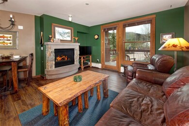 Living room with wood finished floors, a fireplace