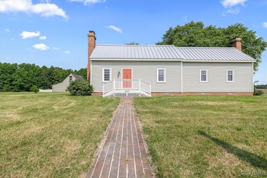View of front of house featuring a chimney, crawl