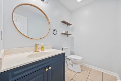 Bathroom with vanity, light tile patterned floors, and a skylight