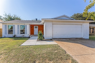 Ranch-style house with brick siding, a front yard, concrete driveway, and roof with shingles