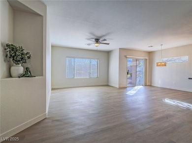 Unfurnished room featuring a ceiling fan, baseboar