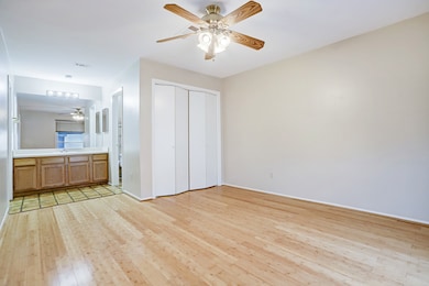 The large primary bedroom features it's own vanity area and a skylight in the bathroom area.