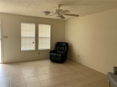 Unfurnished room featuring a ceiling fan, light ti