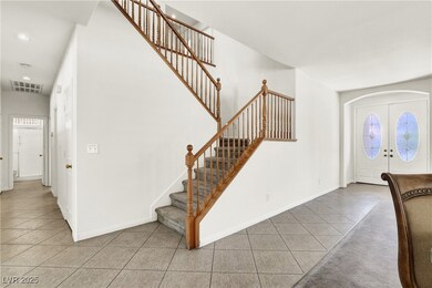Entryway with tile patterned flooring, stairway, f