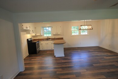 Wood laminate flooring with open den/kitchen area 