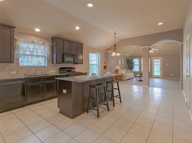 Next on your tour of this home is the large open concept kitchen. It is a beautiful combination of tile flooring, tile backsplash, granite counters, and rich, dark cabinetry. The large island is perfect for additional eating space. There is also a dining area ready to house your breakfast table or your large dining table!
