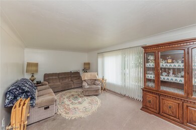 Carpeted living room with ornamental molding