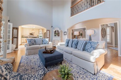 Living area featuring a high ceiling, light wood f