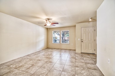 Spare room featuring ceiling fan and light tile p