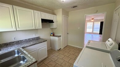 Kitchen featuring a textured ceiling, ceiling fan