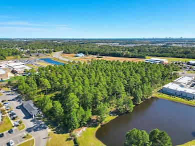 Drone / aerial view of a nearby body of water and a tree filled landscape