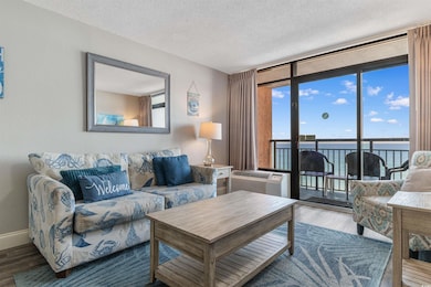 Living area with a textured ceiling, a water view, wood finished floors, a wall mounted AC, and floor to ceiling windows