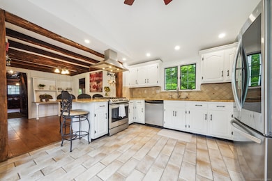 Updated kitchen with wood beams show the history of this home
