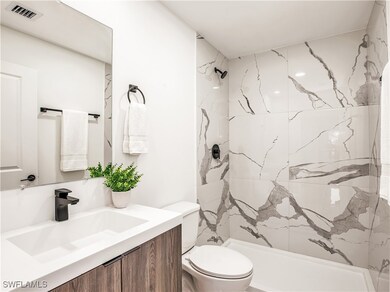Bathroom featuring toilet, a marble finish shower,