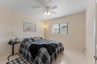 Tiled bedroom with a ceiling fan, baseboards, and 