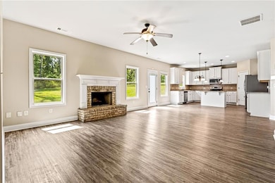 Unfurnished living room with ceiling fan, a fireplace, dark wood-style floors, and recessed lighting