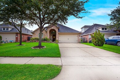 This home has great curb appeal with 2 oak trees in the front yard and a flower bed.