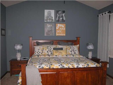 Inviting master bedroom has a vaulted ceiling and 