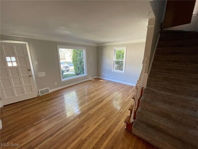 Unfurnished living room with wood-type flooring and crown molding