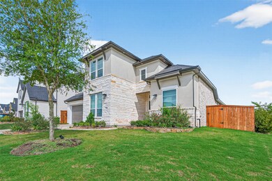 This photo features a modern two-story home with a stone and stucco exterior. It has a well-maintained lawn, a spacious driveway, and a wooden gate leading to the backyard. The house is situated in a suburban neighborhood with similar style homes.