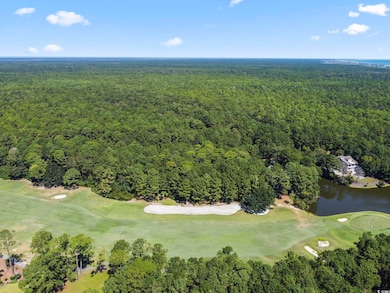 Aerial view of property's location featuring a local golf course and a forest