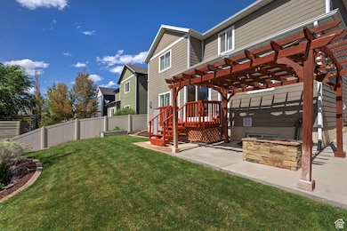 Fenced backyard with an outdoor fire pit, a deck, a patio, and a pergola