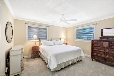 Bedroom with light carpet, a textured ceiling, crown molding, and ceiling fan