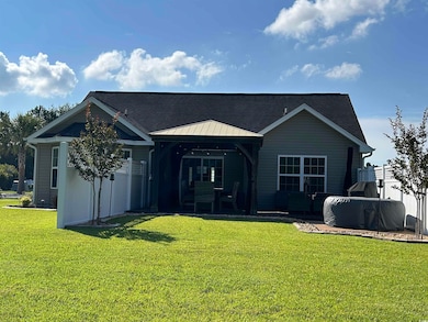 Rear view of property with a gazebo, a yard, and roof with shingles