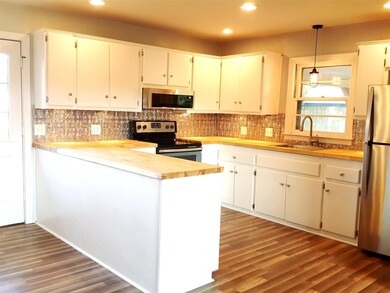 Updated Kitchen with freshly painted Cabinets, New Butcher Block Countertops, New Lighting/Plumbing Fixtures, New Flooring, and New Stainless Steel Appliances.