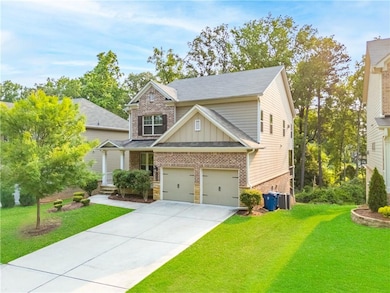 Craftsman house featuring board and batten siding, brick siding, a front lawn, driveway, and cooling unit