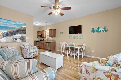 Living room with ceiling fan and light hardwood / 