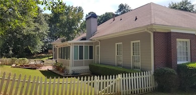 Back of property with a patio, a sunroom, and a la