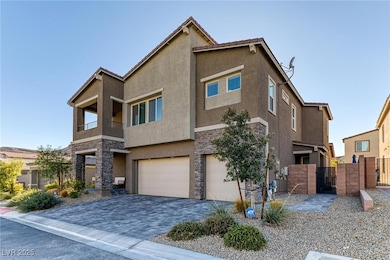 View of front of property featuring stone siding, a gate, stucco siding, and a balcony