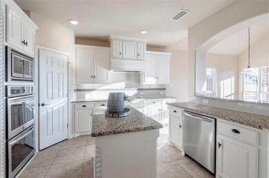 Kitchen with white cabinetry, tasteful backsplash,
