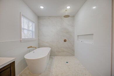 Bathroom featuring vanity, tile walls, and separat