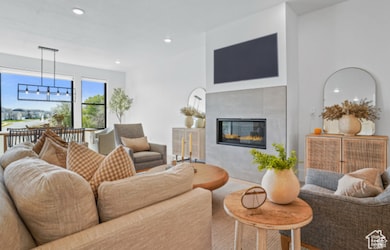 Living room featuring a tiled fireplace and an inviting chandelier