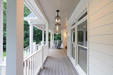 Inviting wraparound porch offers a peaceful view of the surrounding greenery