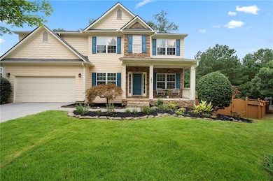 Craftsman-style home with covered porch, concrete driveway, a garage, and stone siding