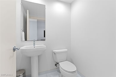 Bathroom with toilet, tile patterned floors, and b