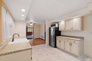 Kitchen featuring recessed lighting, light countertops, stainless steel appliances, ceiling fan, and radiator