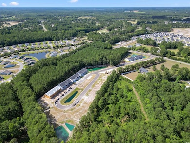Aerial overview of property's location with a forest and nearby suburban area
